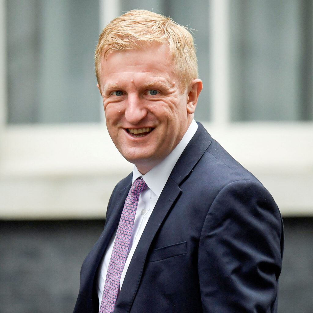 Conservative MP, Deputy Prime Minister and Chancellor of the Duchy of Lancaster Oliver Dowden in long shot turns to his left and smiles at the camera in Downing Street