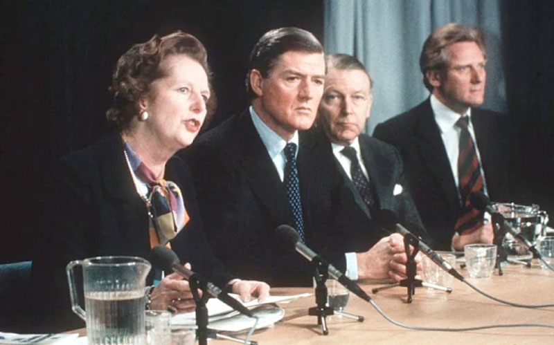 Four Conservative politicians behind a desk at a press conference, microphones in front of them. Left to right: Margaret Thatcher, Cecil Parkinson, Francis Pym and Michael Heseltine