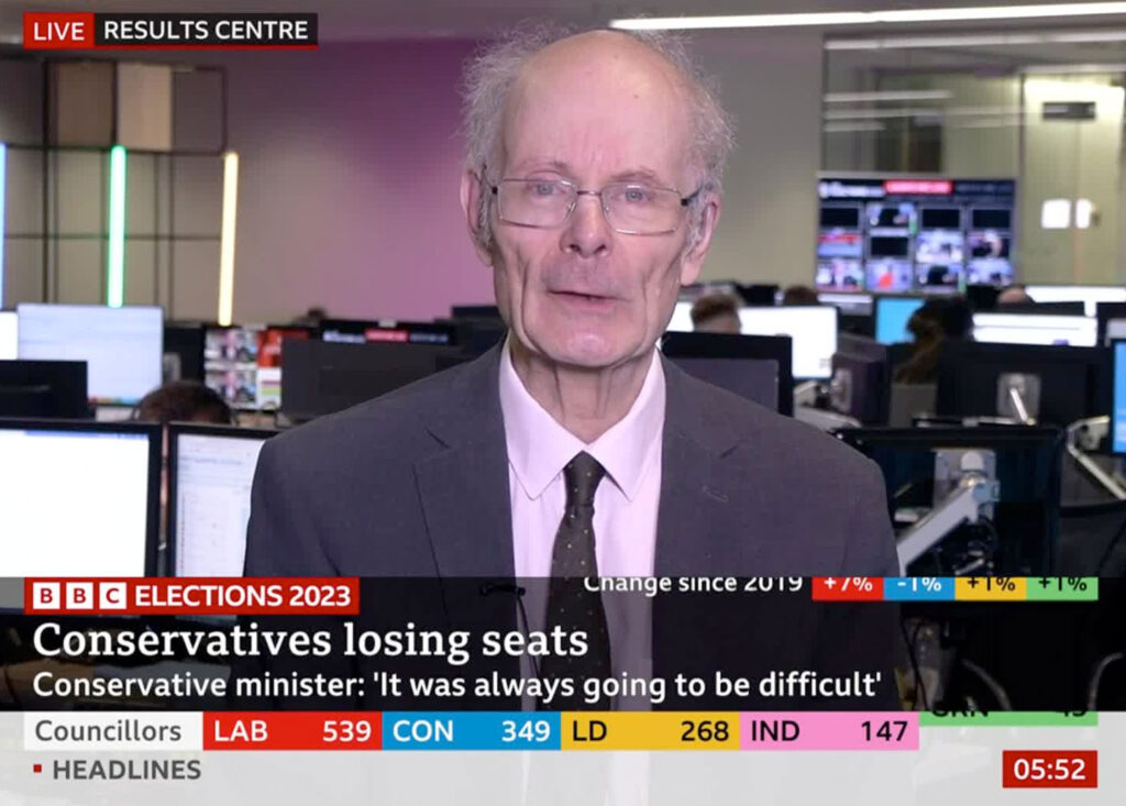 Professor John Curtice in a BBC studio talking to the camera about 2024 council election results. Caption reads: Conservatives losing seats - Conservative minister: 'it was always going to be difficult'